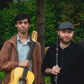 deux hommes posant chacun avec un instrument de musique, une guitare et une flûte
