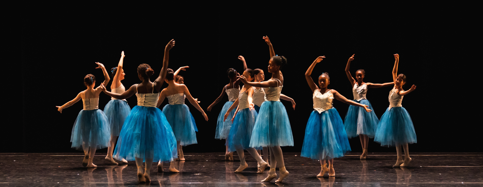 groupe de jeunes filles en tutu bleu performant sur scène lors d'un spectacle